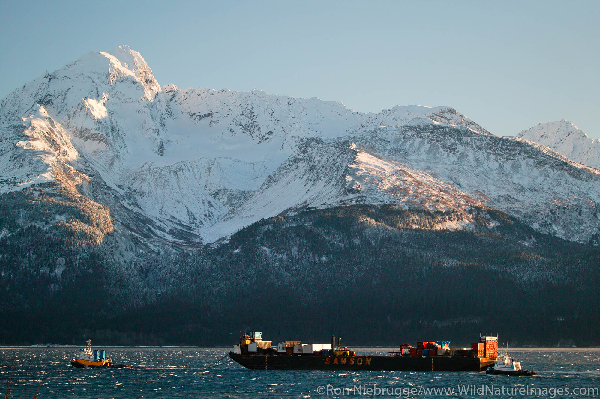 Tug & Barge The Samson Barge St Elias is being towed by the tug Ocean Navigator in Resurrection Bay during the winter, Seward, Alaska.