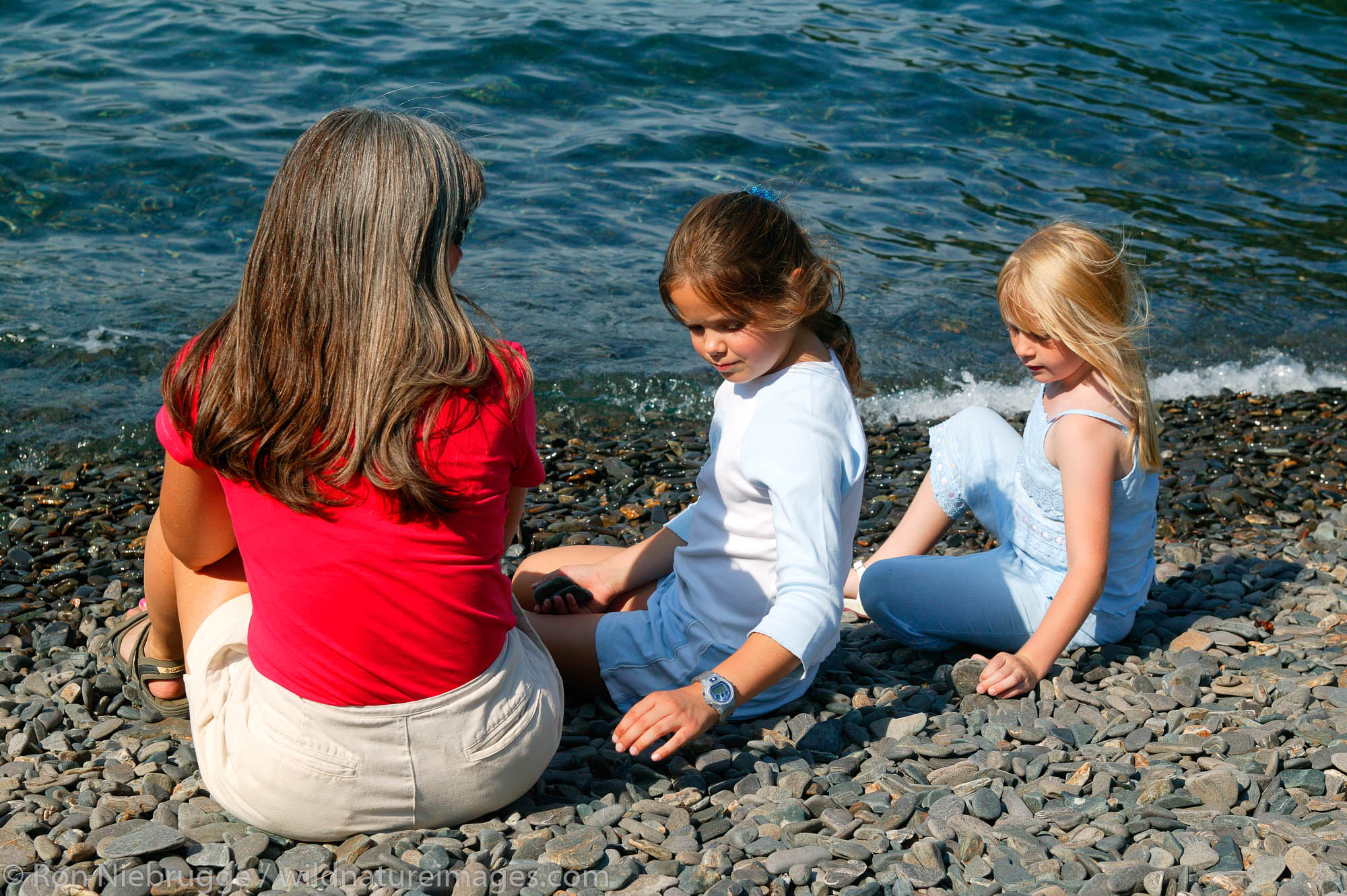 Janine Niebrugge (red) Jessica Wright (blue top) and Savannah Woolston (white top) on the beach of Kenai Fjords Tours property...