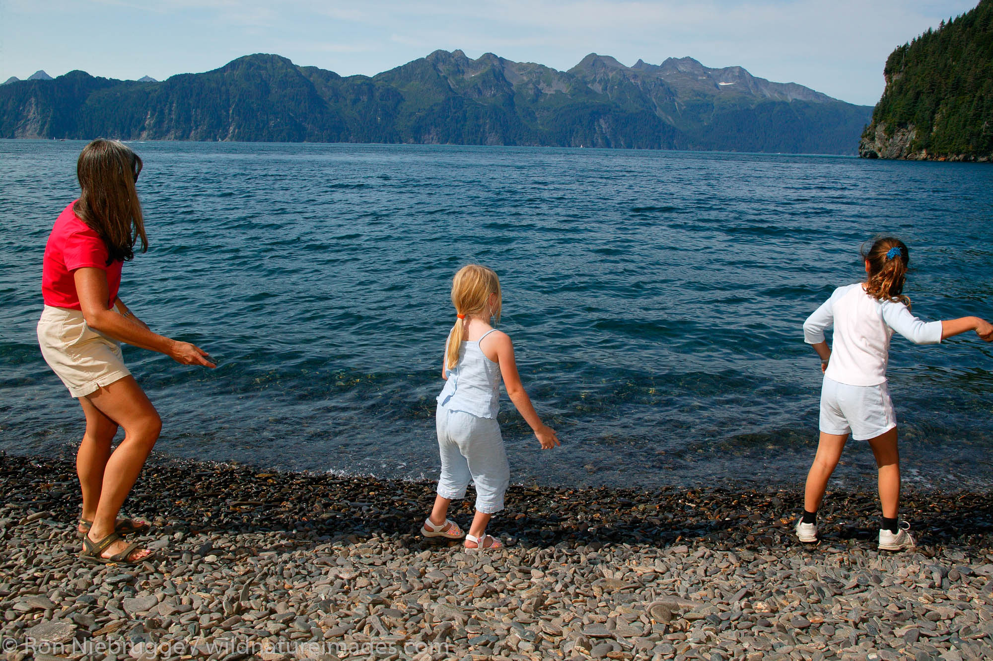Janine Niebrugge (red) Jessica Wright (blue top) and Savannah Woolston (white top) on the beach of Kenai Fjords Tours property...