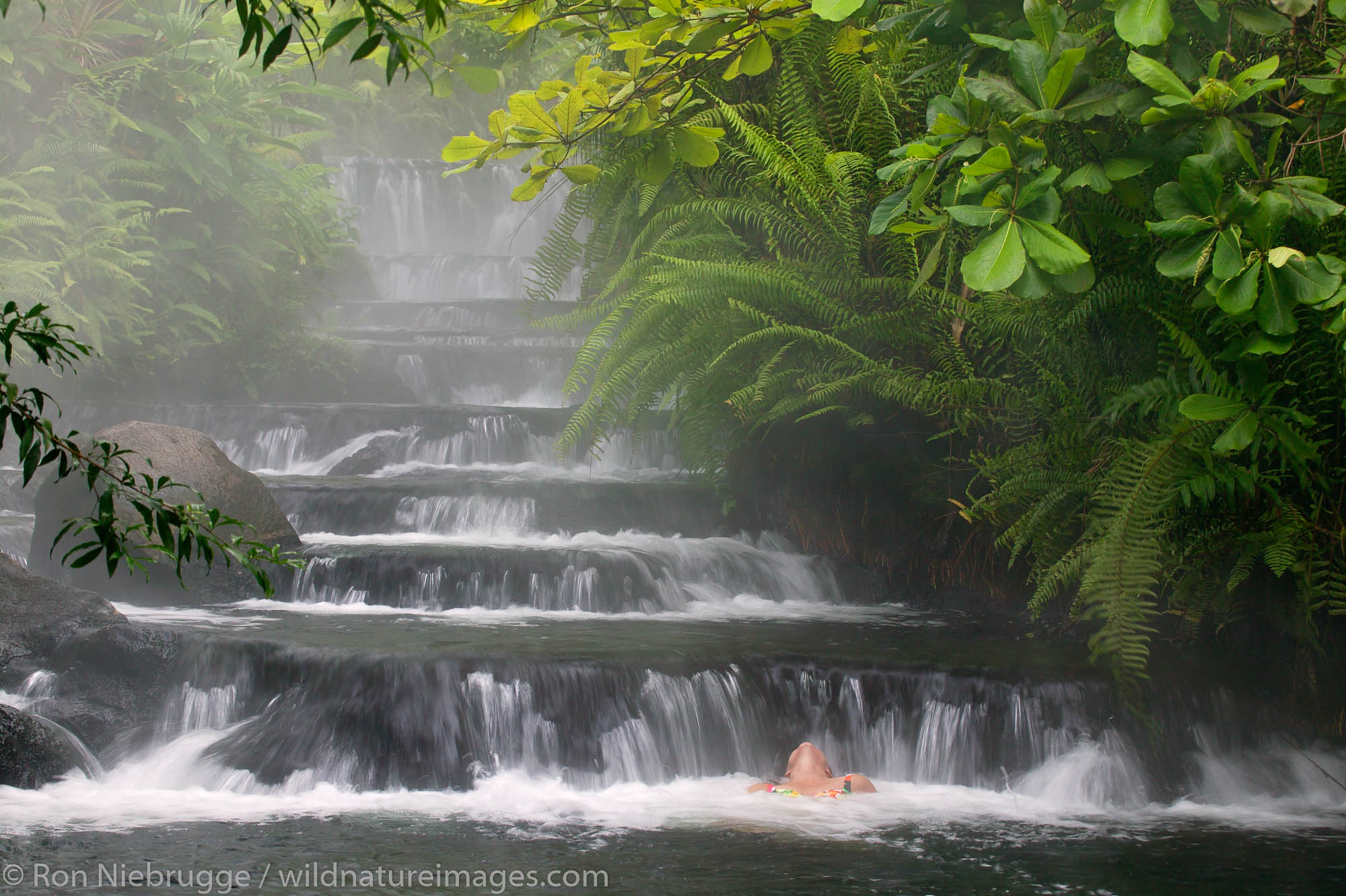 A visitor (mr) enjoys one of the warm streams that flows through Tabacon Hot Spring Resort and Spa, Costa Rica.
