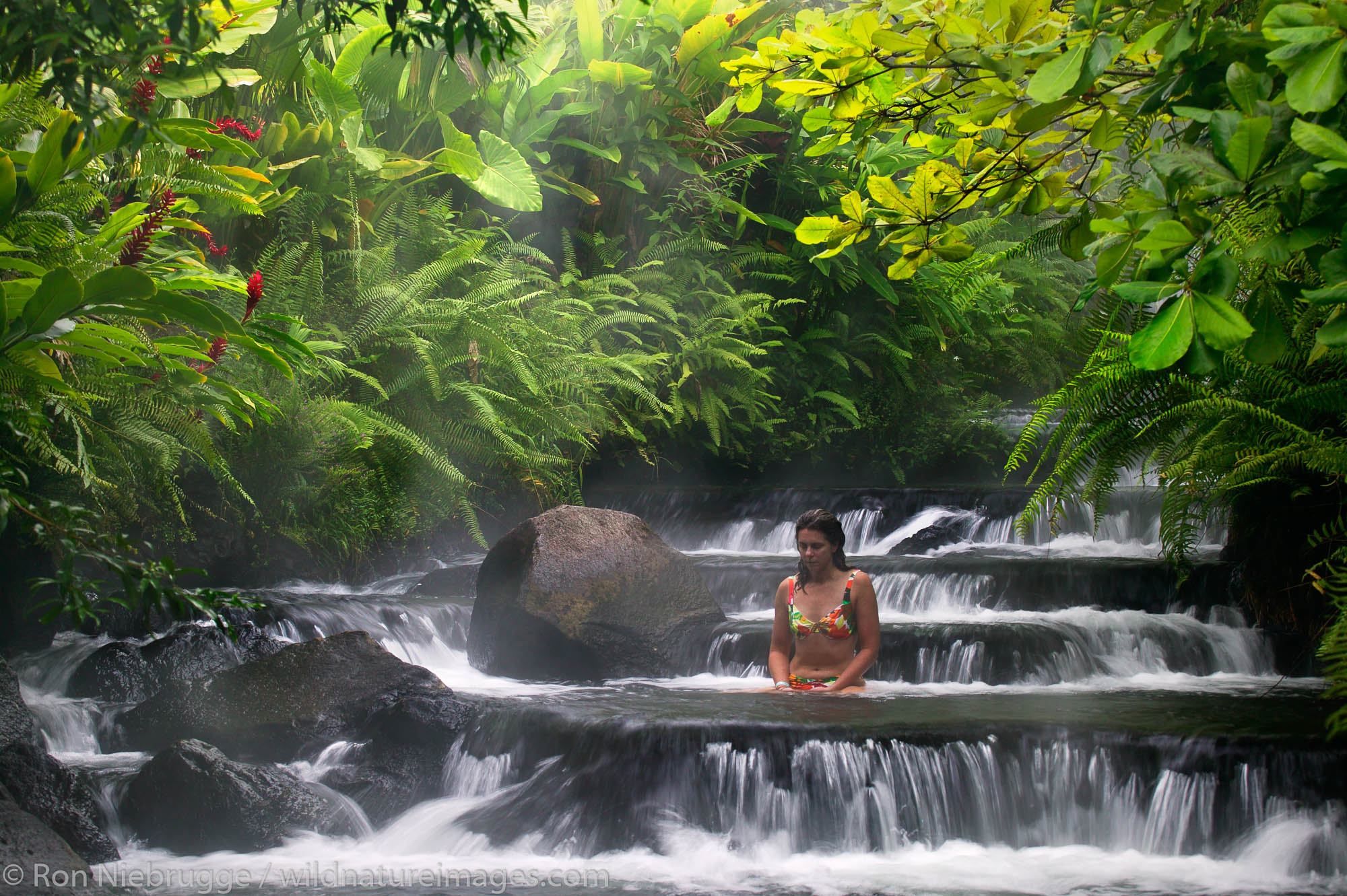 A visitor (mr) enjoys one of the warm streams that flows through Tabacon Hot Spring Resort and Spa, Costa Rica.