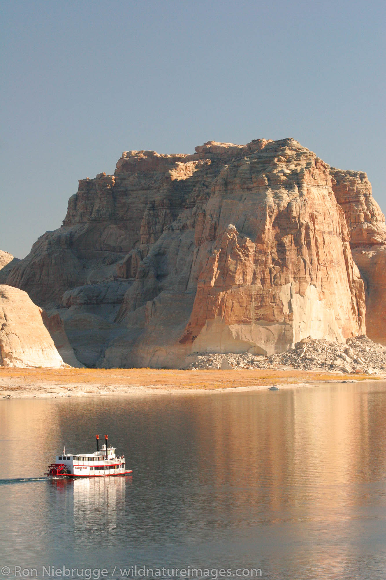 A tour boat passes by the Lone Rock Campground, Lake Powell and the Glenn Canyon Recreation Area, Utah.  This is near Page, Arizona...