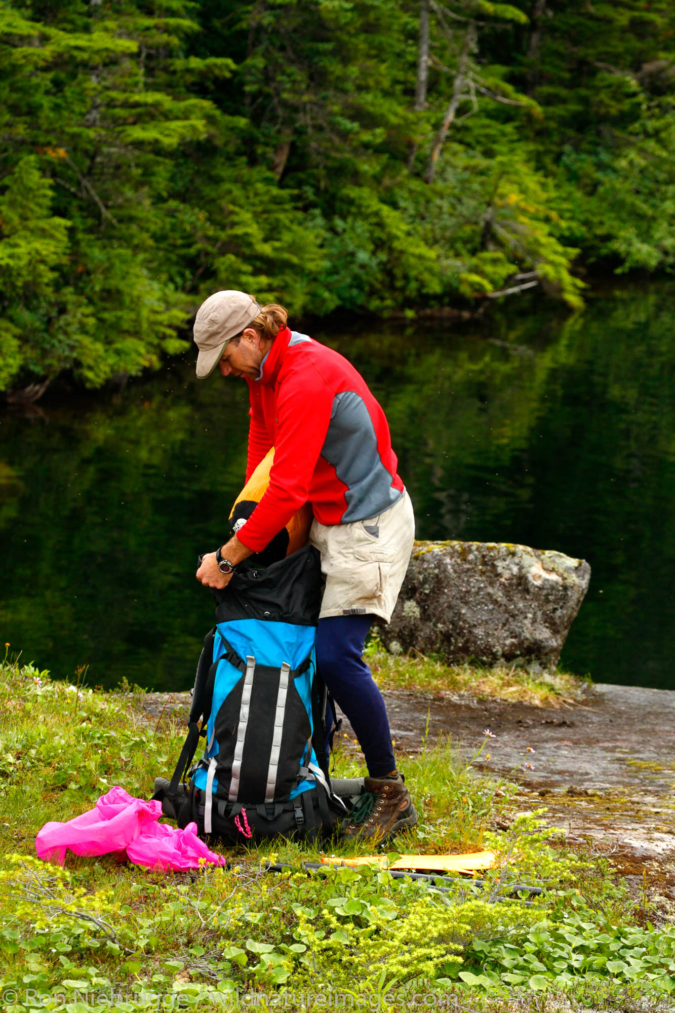A hiker packs up his backpack, Chugach National Forest, Prince William Sound, Alaska.  (Model Released)
