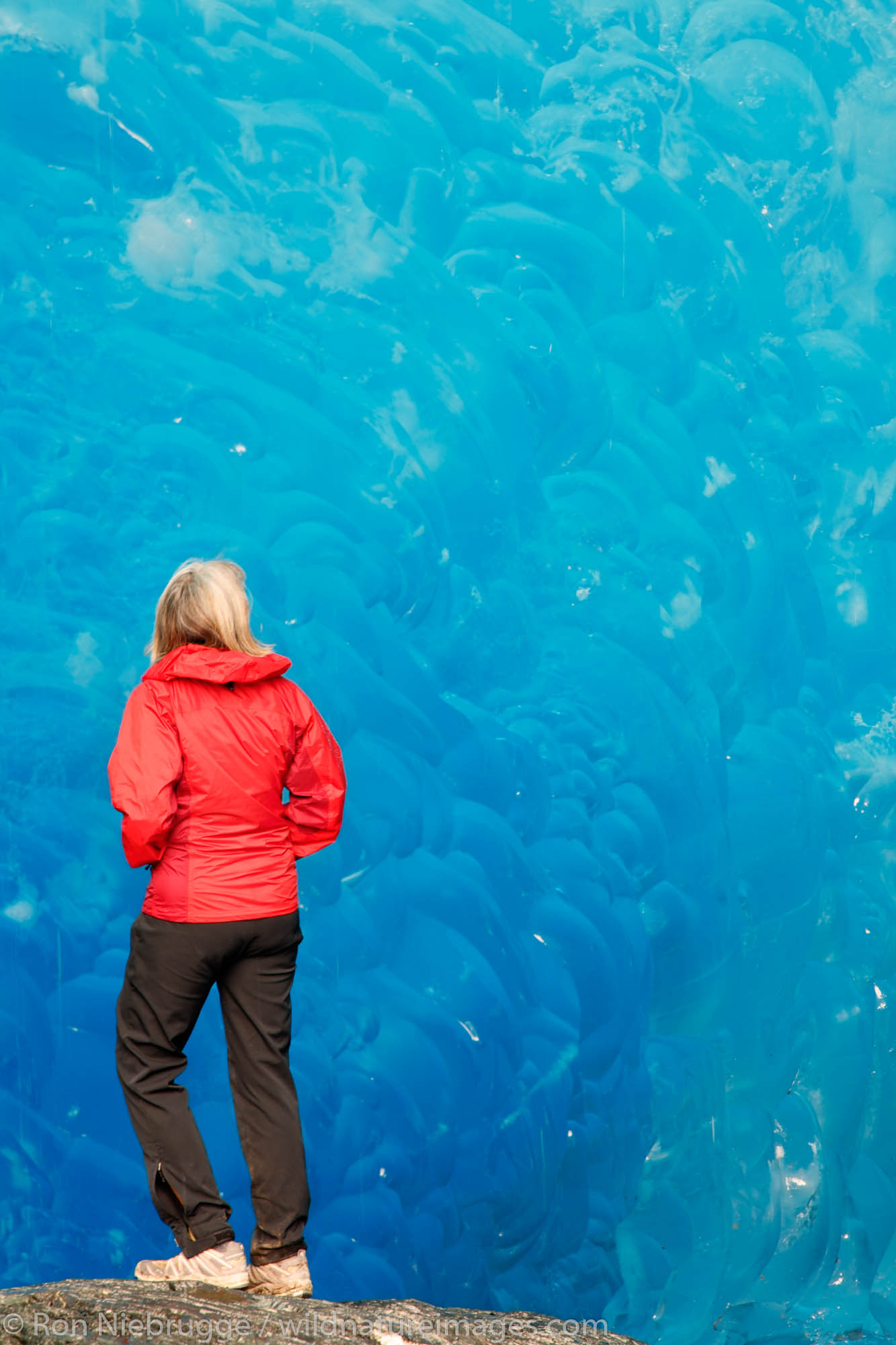 A hiker in an ice cave in Mendenhall Glacier, Juneau, Alaska.