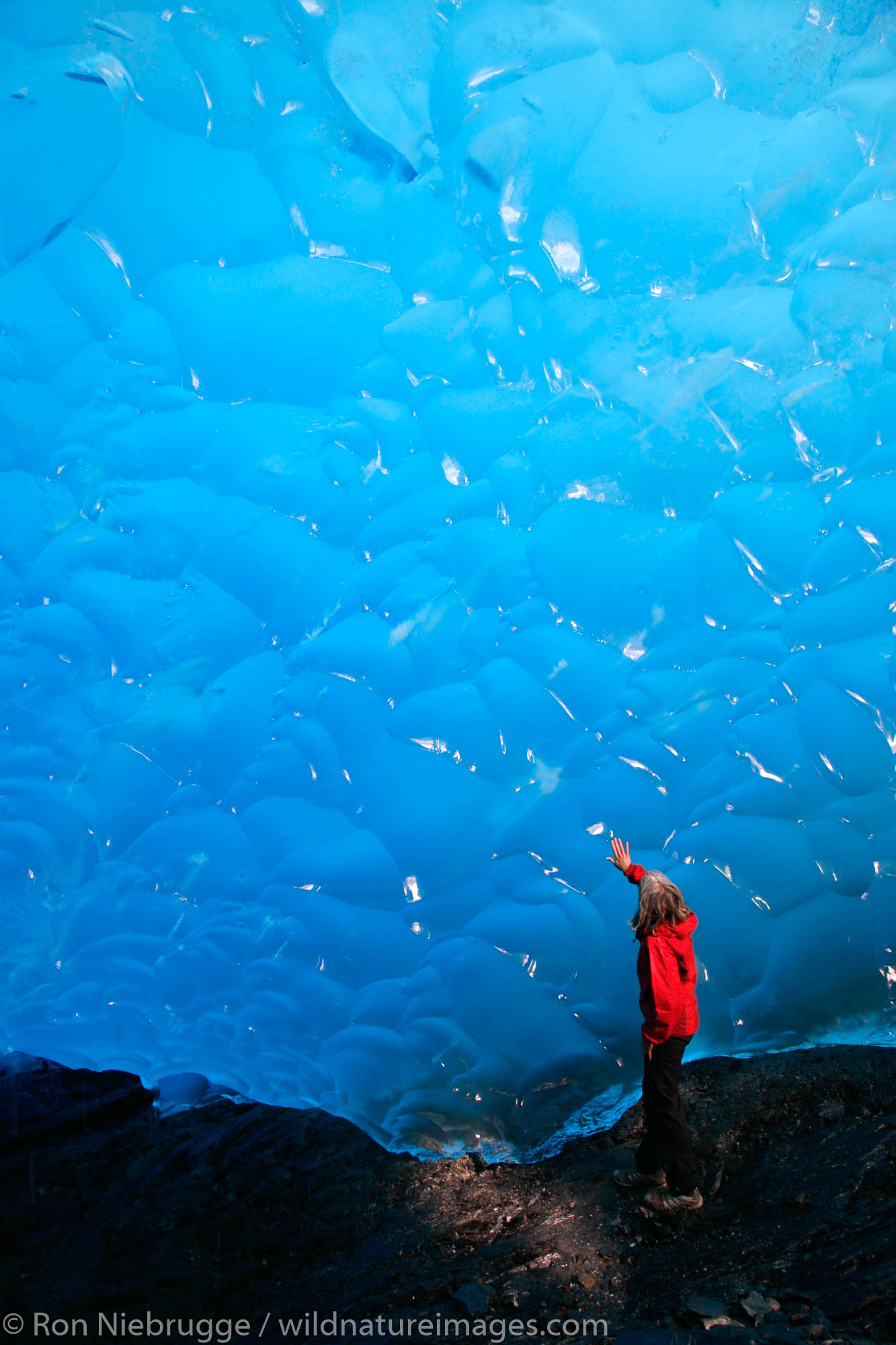 A hiker in an ice cave in Mendenhall Glacier, Juneau, Alaska.