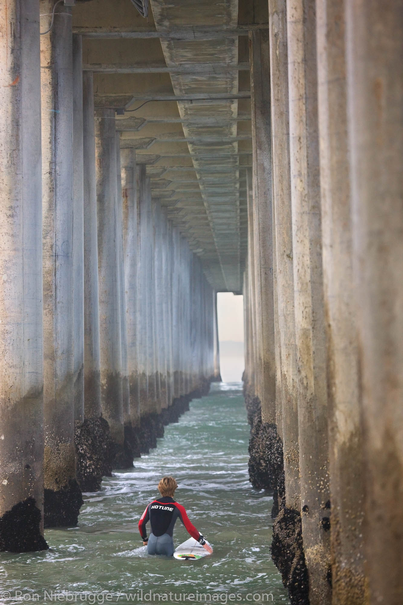 Surfers near the pier, Huntington Beach, Orange County, California.