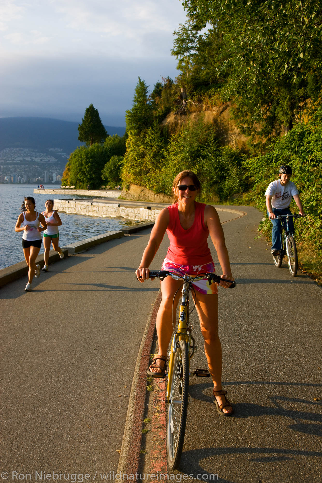 Bike riding on the coastal trail in Stanley Park, Vancouver, British Columbia, Canada.  (model released)