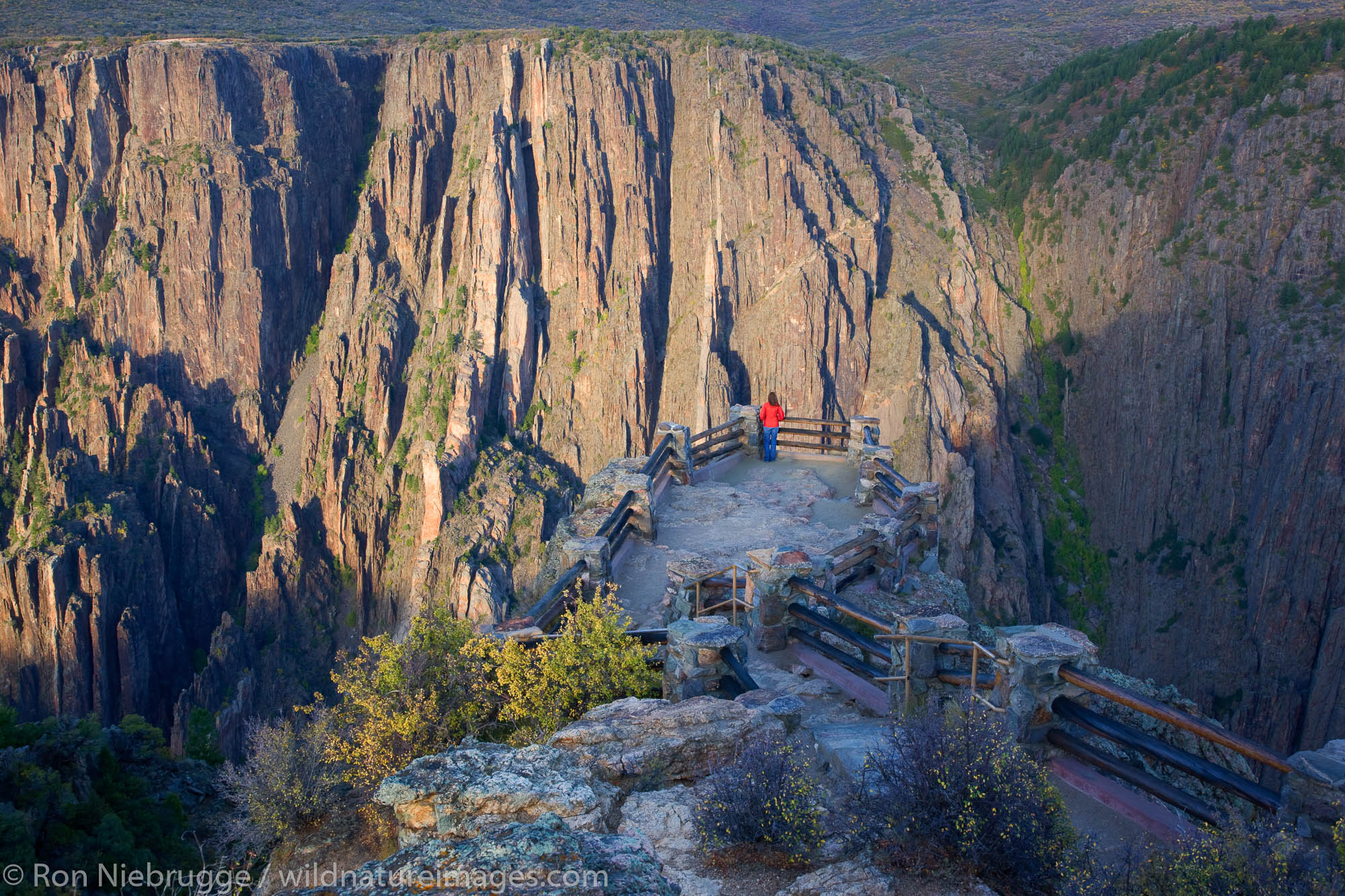 A hiker enjoys the viewpoint at Gunnison Point, Black Canyon of the Gunnison National Park, Colorado.  (model released)