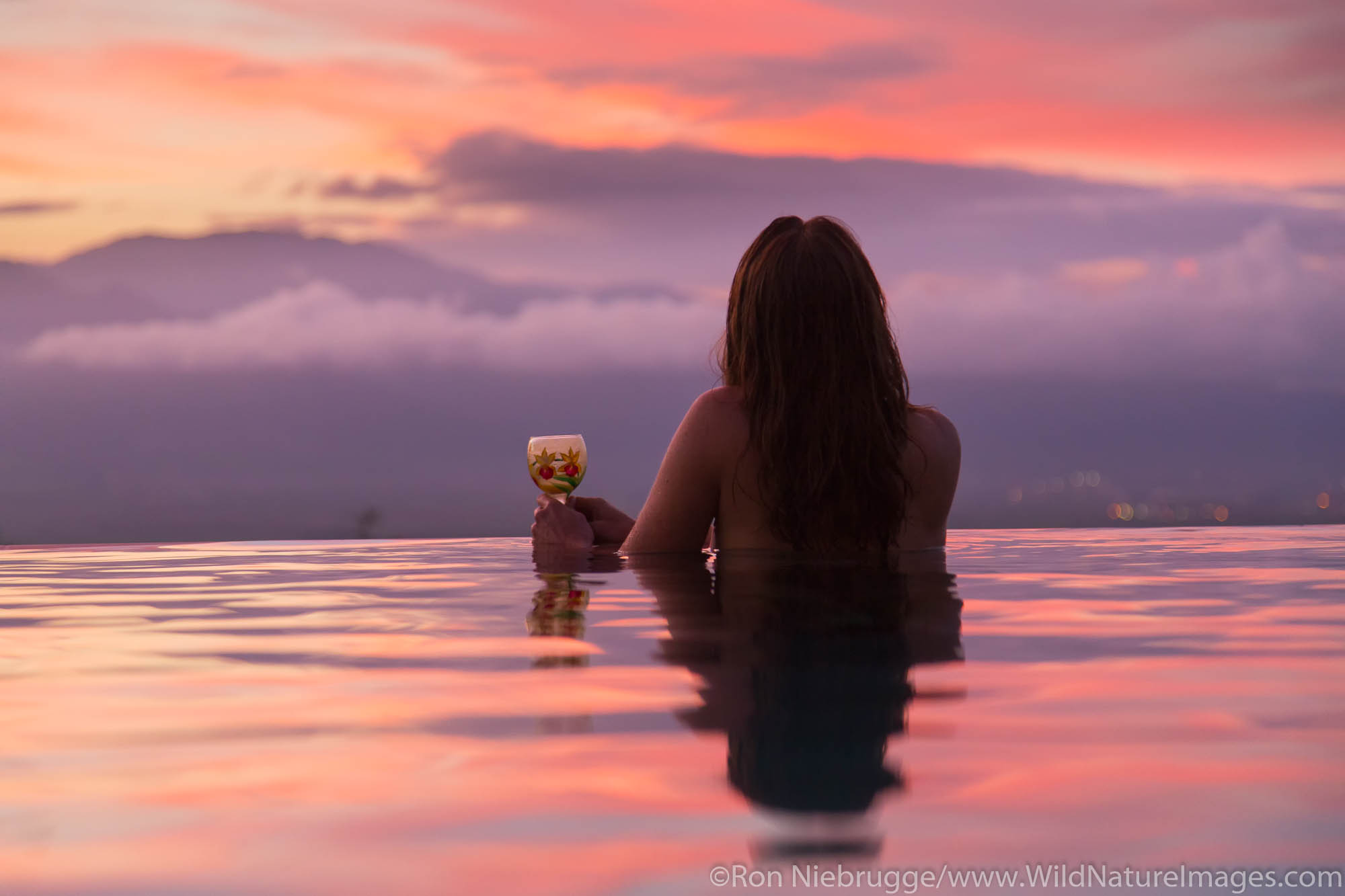A visitor enjoying sunset from an infinitely pool, Maui, Hawaii.  (model released)