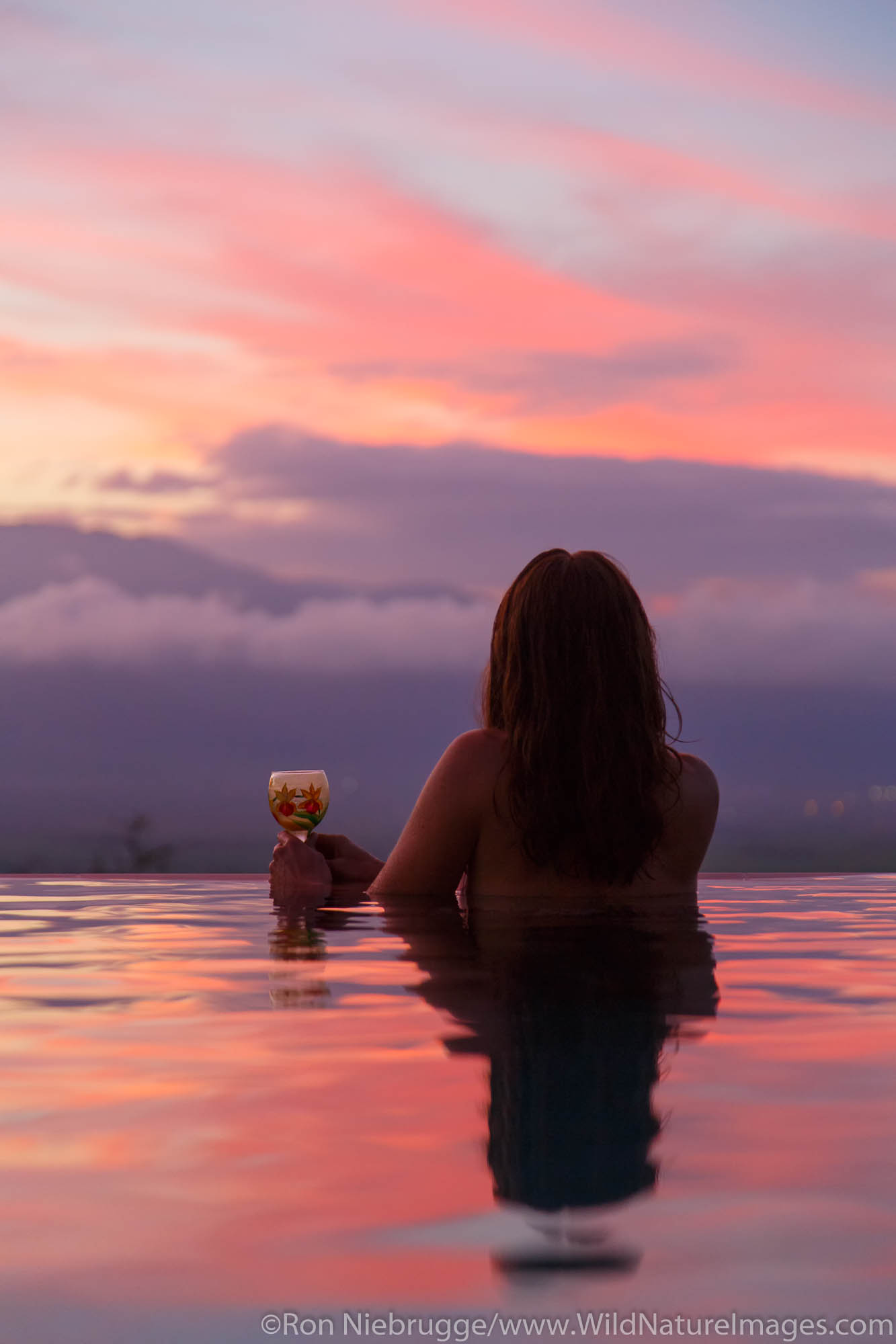 A visitor enjoying sunset from an infinitely pool, Maui, Hawaii.  (model released)