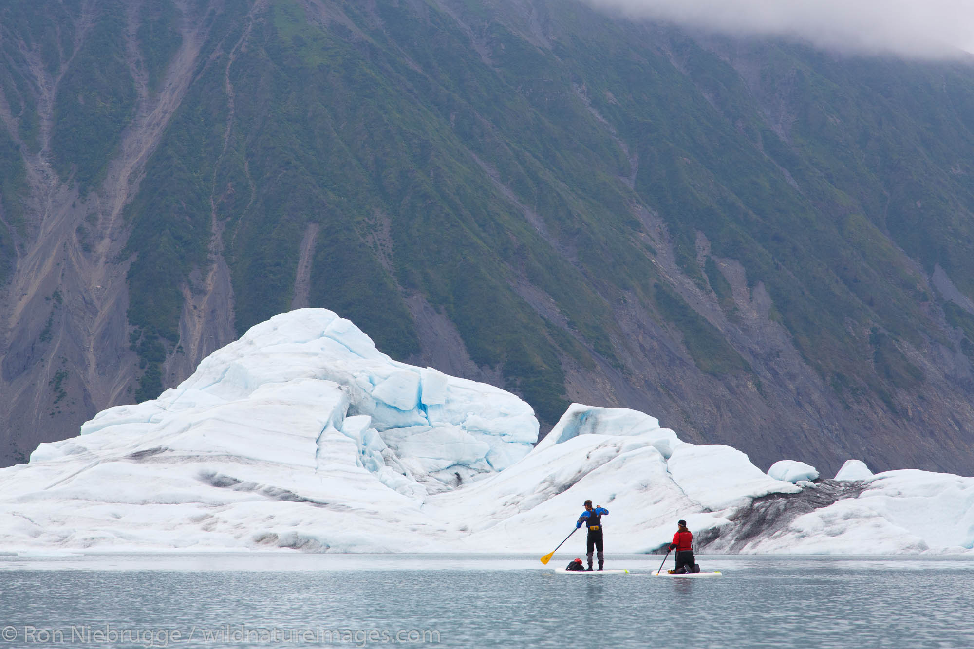 Stand up paddle boarding in Bear Glacier Lagoon, Kenai Fjords National Park, near Seward, Alaska.