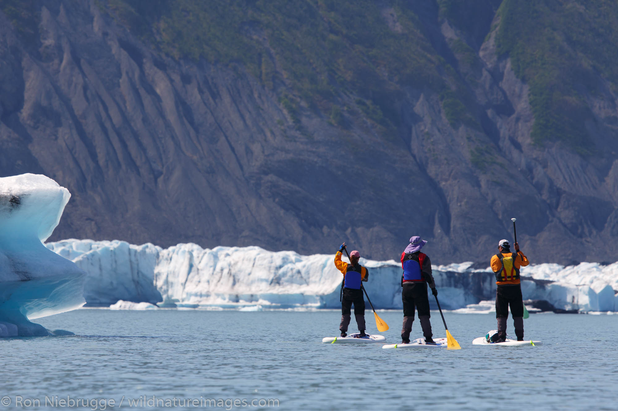 Stand up paddle boarders in Bear Glacier Lagoon, Kenai Fjords National Park, near Seward, Alaska.