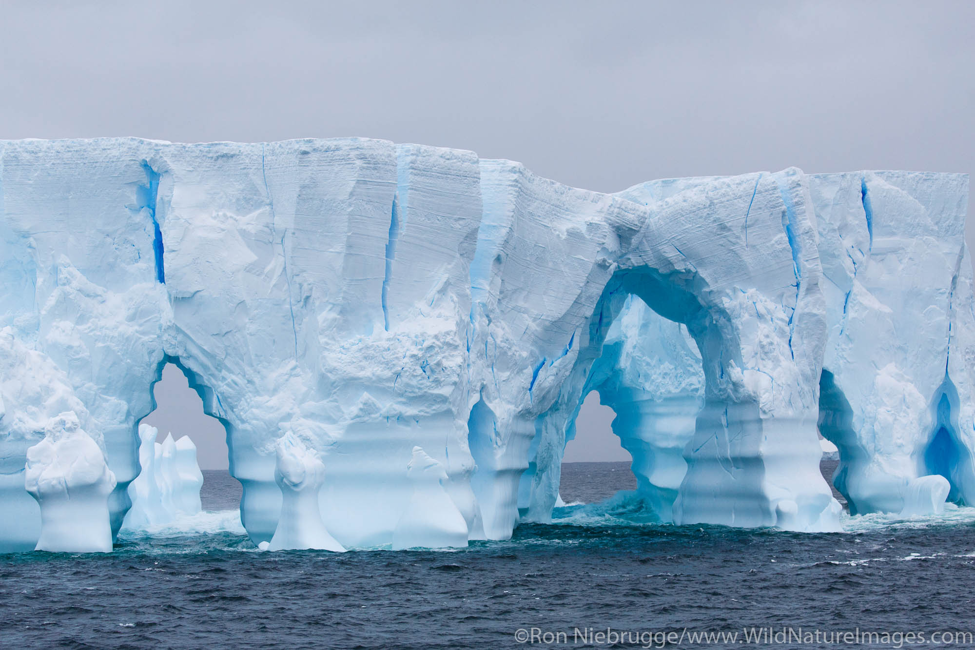 Huge arched iceberg south of the Antarctica Circle, Antarctica.