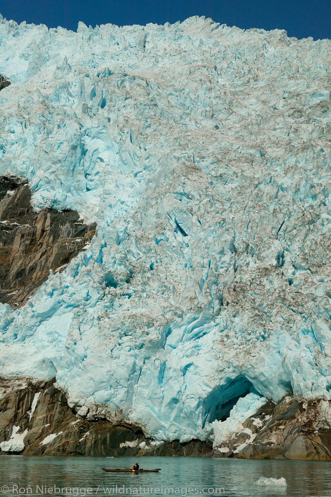 Kayakers in front of Northwestern Glacier, in Northwestern Fjord, Kenai Fjords National Park, Alaska.